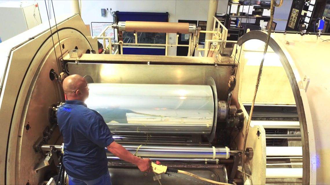 Man working on magnetron sputtering machine.