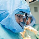 Close up of man in surgery wearing surgical suit.